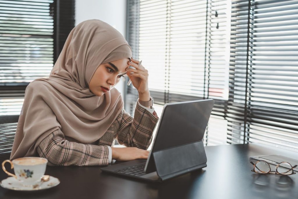Women with hijab stress infront of laptop